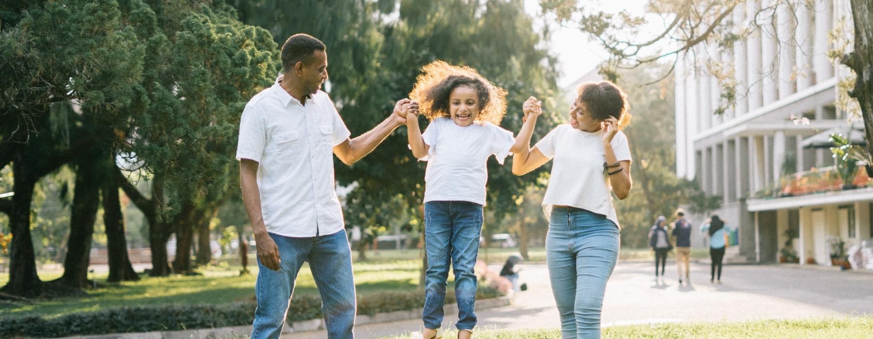 a family holding hands in a park