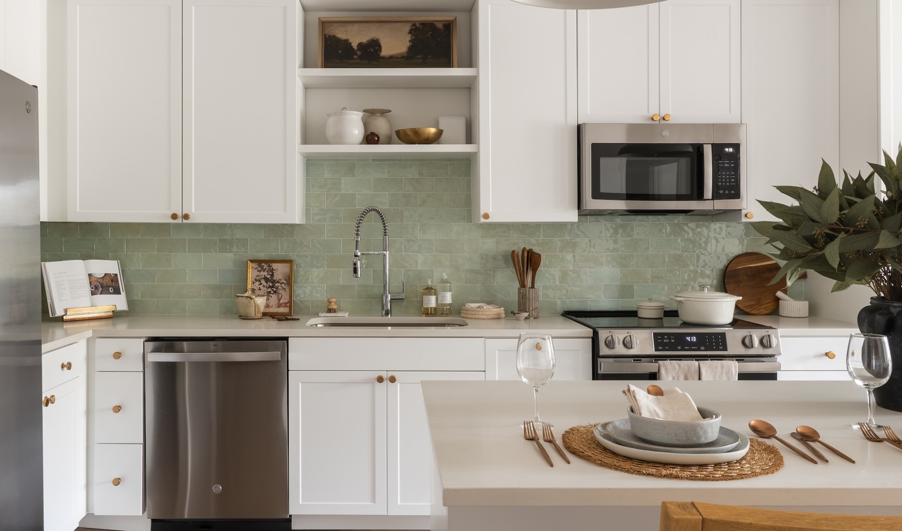Modern apartment with white cabinets and green tile backsplash
